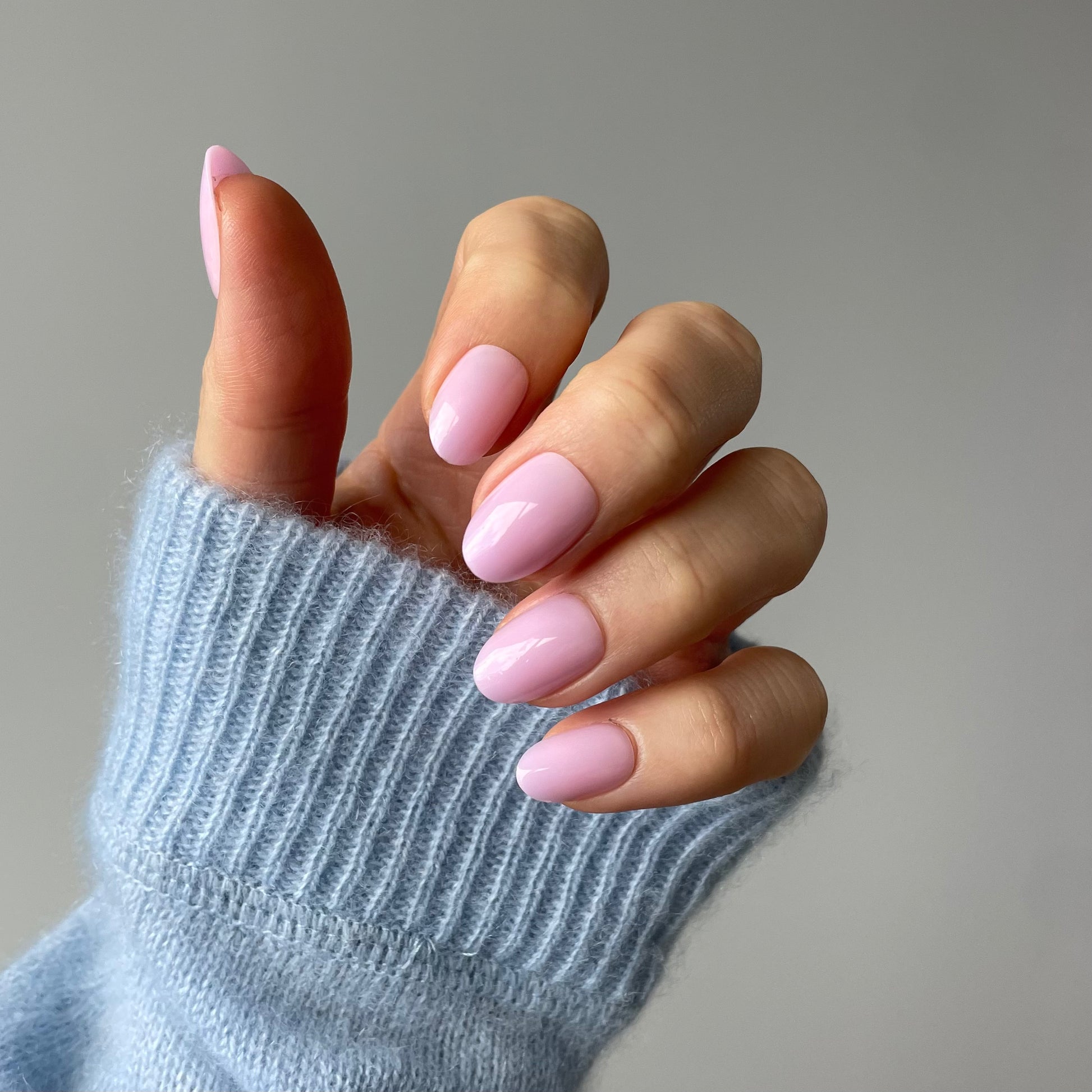 Womans hand with Candy Claws press-on nails in a semi-sheer lilac haze with a pink-lavender undertone